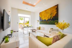 un soggiorno con divano bianco e un dipinto sul muro di Tiara Beach Residences, Palm Jumeirah Dubai - Mint Stay a Dubai