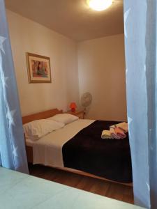 een slaapkamer met een bed met een zwarte deken bij Apartments Kokotic in Bol