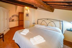 een slaapkamer met een wit bed en 2 handdoeken bij Maison Quintavalle 20 in Assisi