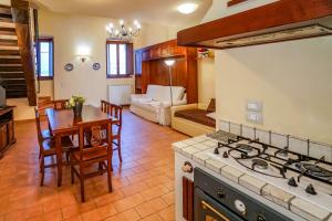 een keuken en een woonkamer met een fornuis en een tafel bij Maison Quintavalle 20 in Assisi