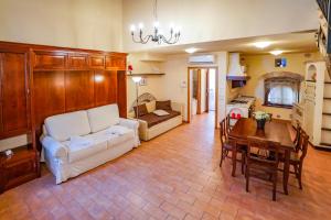 een woonkamer met een witte bank en een tafel bij Maison Quintavalle 20 in Assisi