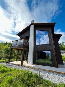 a house with glass windows on the side of it at Exclusive Penthouse Apartment with Sauna - 102 in Stranda