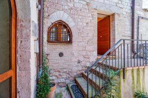 een stenen gebouw met een trap en een raam bij Maison Quintavalle 20 in Assisi