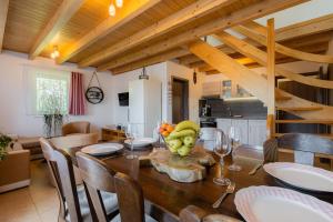 a kitchen and dining room with a table with wine glasses at Apartments Nad Rybníky in Horní Planá