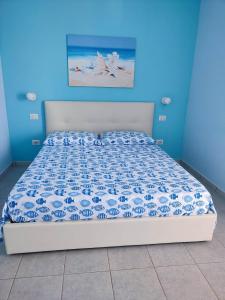 a bed in a bedroom with a blue wall at Porto Selvaggio Casa Zaffiro in Torre Inserraglio