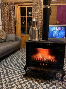 a fireplace with a tea kettle in a living room at Şirince mağara deresi evleri. in Selcuk