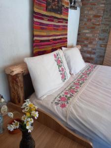 1 cama con 2 almohadas y almohada de flores en Şirince mağara deresi evleri. en Selcuk