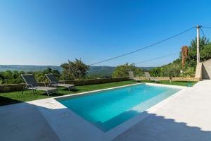 a swimming pool with two chairs and a view at Villa Casa Libera in Livade