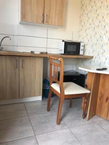 a kitchen with a chair and a microwave on a counter at Trzy Żagle in Mikołajki