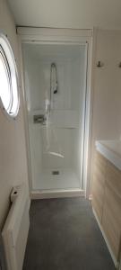 biała łazienka z prysznicem i umywalką w obiekcie Camping Parc des 7 Fonts w mieście Agde