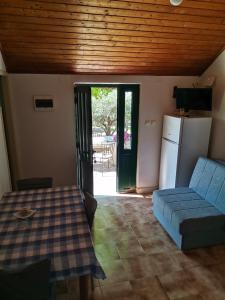 een woonkamer met een blauwe bank en een koelkast bij Holiday home Oliva cottage in Bol