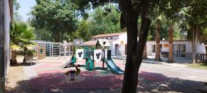 einen Spielplatz mit Rutsche in einem Park in der Unterkunft Camping Parc des 7 Fonts in Agde