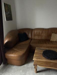 a brown leather couch in a living room with a coffee table at Chata Mazurska in Orzysz