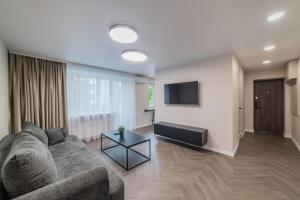 a living room with a couch and a flat screen tv at Frida Apartment in Šiauliai