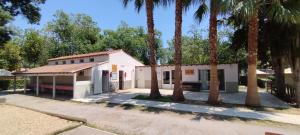 a white building with palm trees in front of it at Camping Parc des 7 Fonts in Agde