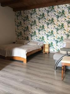 1 dormitorio con 1 cama y una pared con palmeras en Trzy Żagle, en Mikołajki