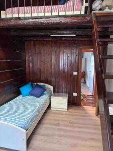 łóżko w pokoju z drewnianą ścianą w obiekcie Casa Hope w mieście Vasanello