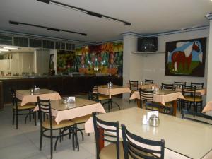 a restaurant with tables and chairs and a bar at Titão Plaza Hotel in Campina Grande