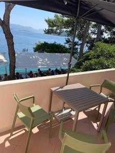 una mesa con sillas y una sombrilla en el balcón en Rondina House, en Korčula