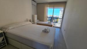 a bedroom with a large white bed and a balcony at Apartamento Acacias IV -5 in Benidorm