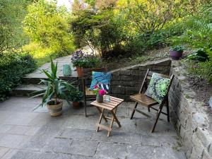 a patio with two chairs and a table with flowers at 1 Zimmer Whg Waldfischbach in Waldfischbach-Burgalben