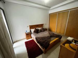 a bedroom with a bed with a wooden headboard at Cozy Apartment with Pool near Beach in Mohammedia