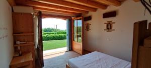 Volpago del MontelloにあるAgriturismo Dolce Colleのベッド1台とガラスのスライドドアが備わる客室です。