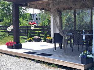 a gazebo with a table and chairs and flowers at Kullerkupu Hostel in Kuressaare