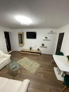 a living room with white furniture and a flat screen tv at Zya Home Central in Oradea