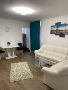 a living room with a white couch and a table at Zya Home Central in Oradea
