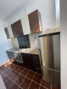 a kitchen with brown cabinets and a stainless steel refrigerator at Zya Home Central in Oradea