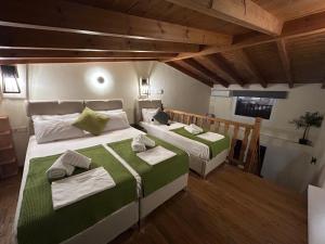 a bedroom with two beds with green and white sheets at Green Olive Studios in Áyios Mámas