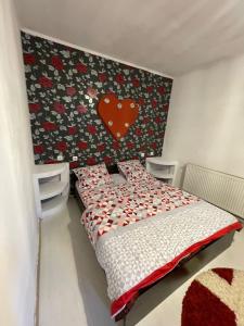 a bedroom with a bed with a red heart on the wall at Zya Home Central in Oradea