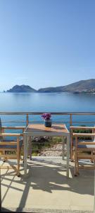 a table and two chairs sitting next to a lake at Theasis Limnos - 1st floor suite in Agios Ioannis Kaspaka