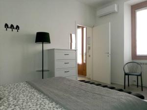 a bedroom with a bed and a chair and a dresser at Appartamento Verde in Como