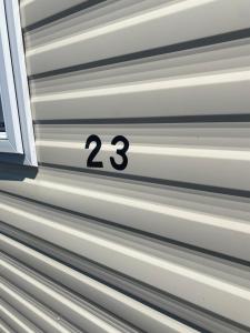 Una pared de metal con el número 23. en Dizzard 23, en Bridgerule