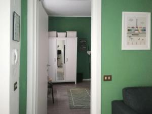 uma sala de estar com paredes verdes e um espelho em Appartamento Verde em Como