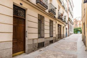 un callejón vacío con una puerta marrón en un edificio en Studio La Latina by SharingCo, en Madrid