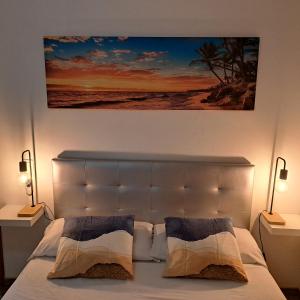 1 dormitorio con 1 cama con una pintura en la pared en Bluebeach en Las Palmas de Gran Canaria