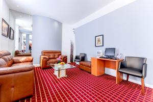 uma sala de estar com mobiliário de couro e um tapete vermelho em Brunel Hotel em Londres