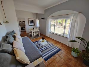 a living room with a couch and a window at Quinta de Lagos in Lagos