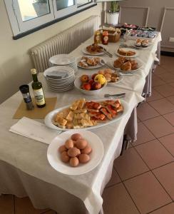 una mesa larga con platos de comida. en Residence Borgomare, en Albenga