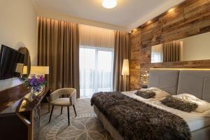 a bedroom with a bed and a desk and a television at Sandra Spa Karpacz & Aquapark in Karpacz