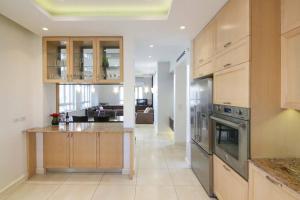 a large kitchen with wooden cabinets and stainless steel appliances at Spacious & Modern 5 bed in the Center of Rechavia! in Jerusalem