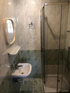 uma casa de banho com um lavatório e um chuveiro em Noclegi Rynek 12 em Lesko