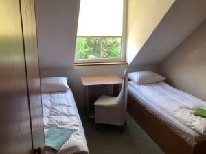 um quarto com 2 camas, uma secretária e uma janela em Noclegi Rynek 12 em Lesko