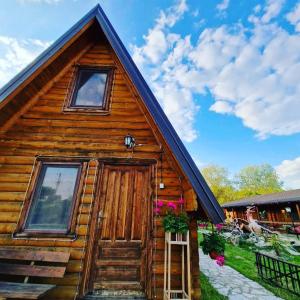 a log cabin with a door and windows at Lolini bungalovi in Novi Sad