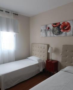 1 dormitorio con 2 camas y mesa con lámpara en Mogan Sol, en Puerto de Mogán