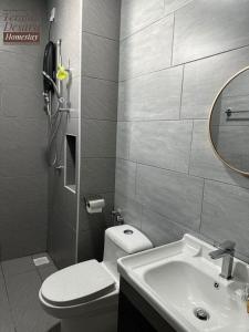 a bathroom with a toilet and a sink and a mirror at Teratak Desaru Homestay Wi-fi, Smart TV & Water Dispenser in Bandar Penawar