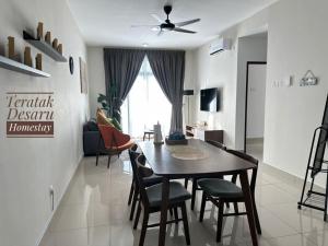 a dining room and living room with a table and chairs at Teratak Desaru Homestay Wi-fi, Smart TV & Water Dispenser in Bandar Penawar